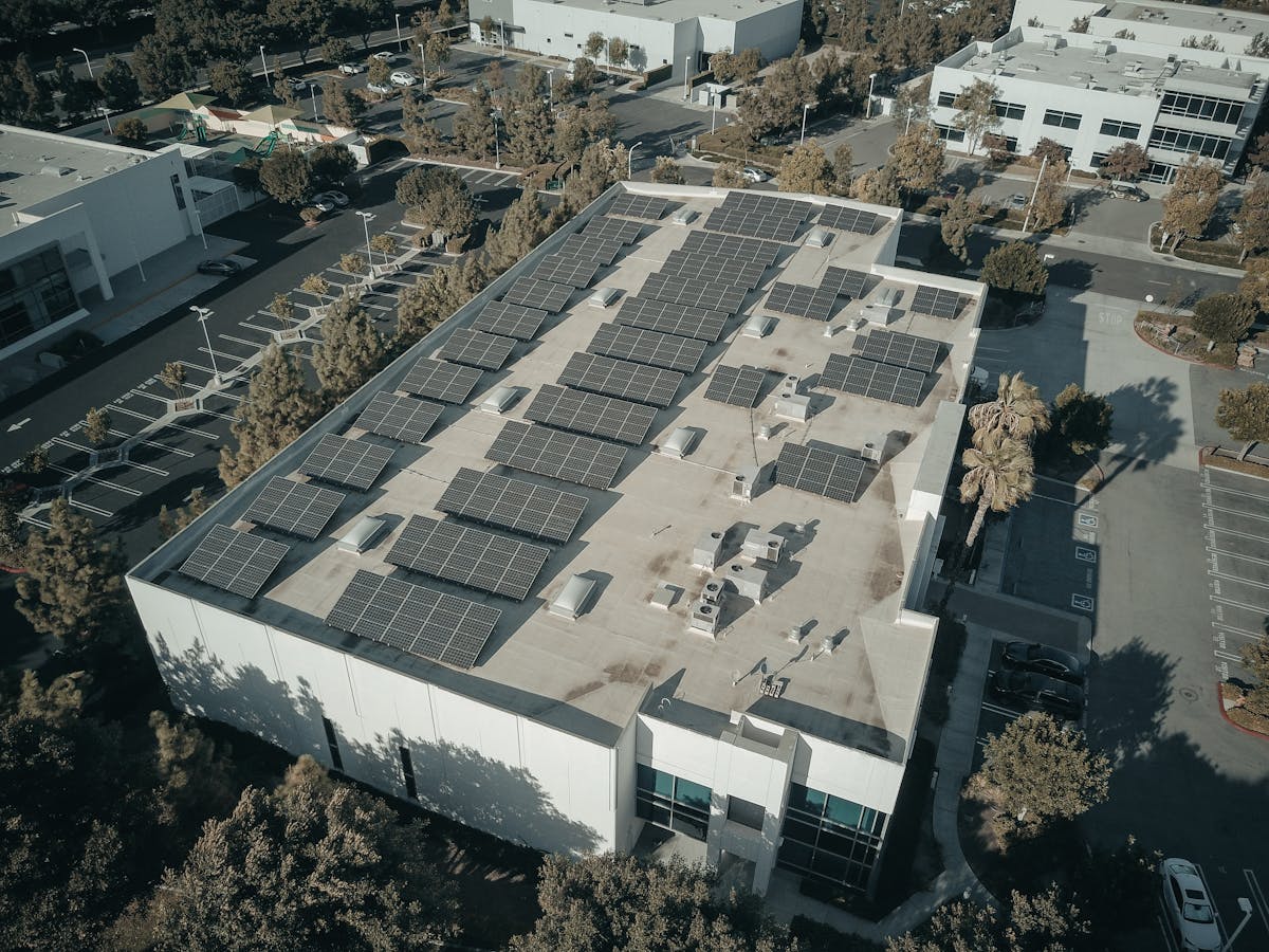 Aerial view of multi-family apartment building with solar panels on rooftop in urban Hawaii